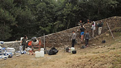 Jóvenes y monitores trabajan en el afianzamiento de un muro.