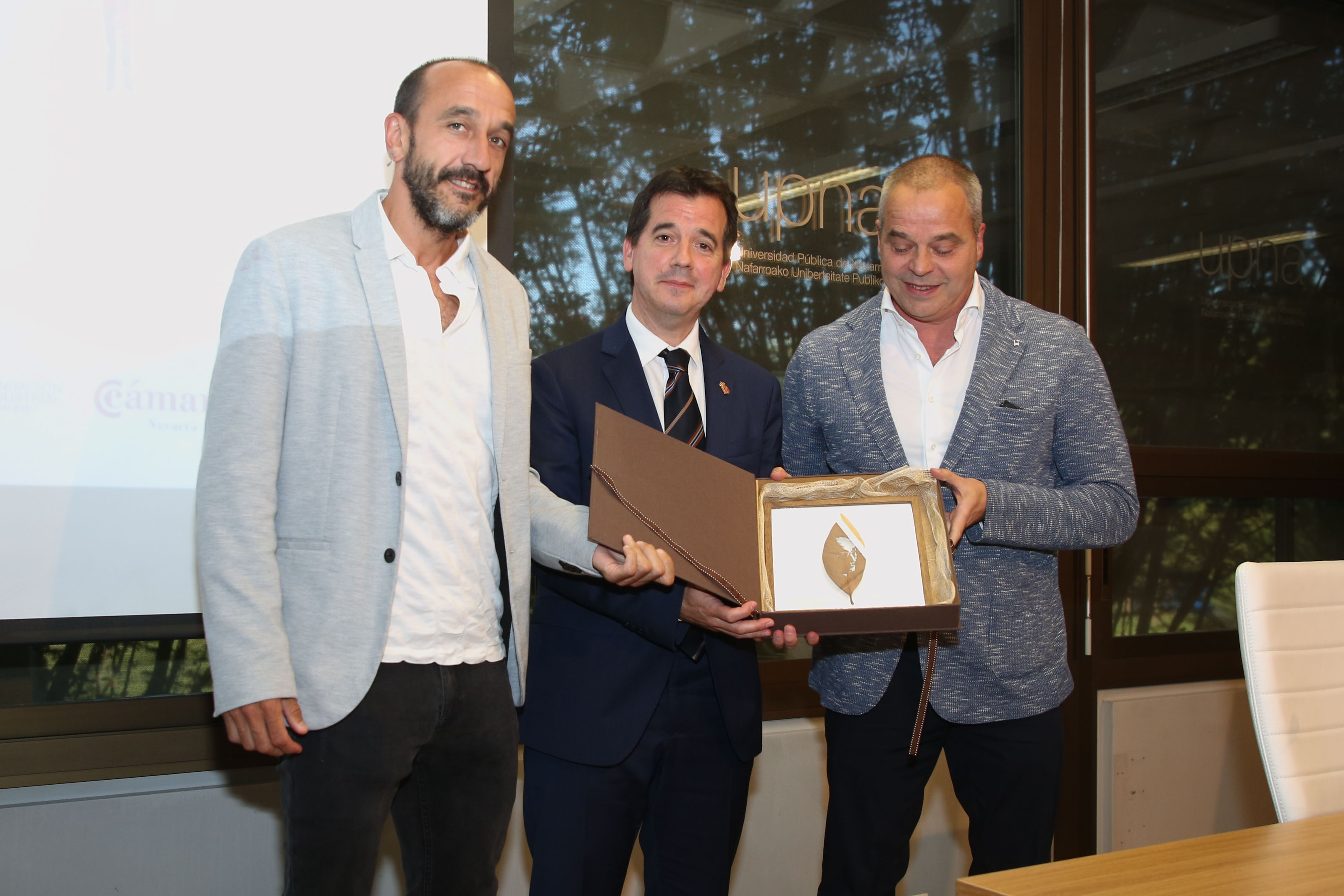 Ander Azcárate, el consejero Irujo y Mikel Azcárate muestran el premio de 
la Fundación Arizmendiarrieta.
