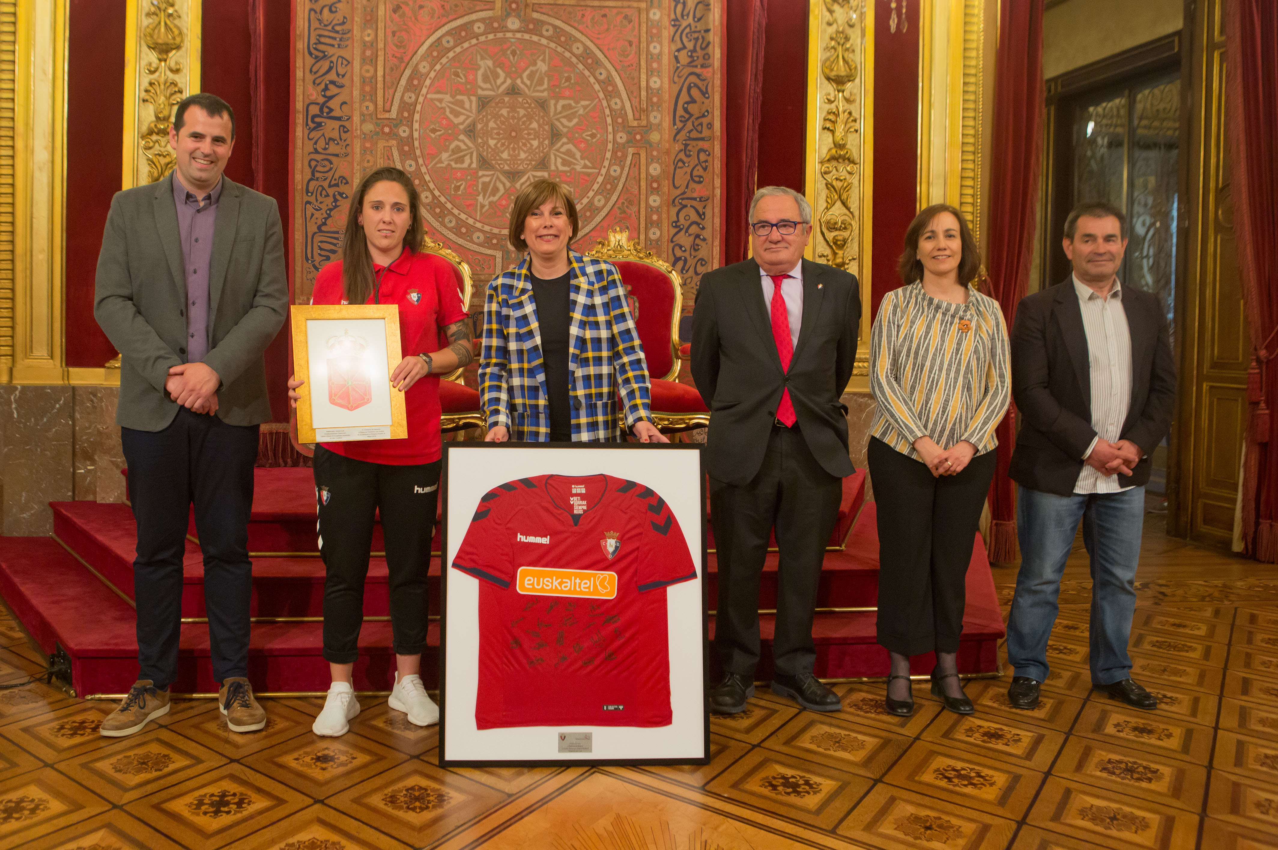 Presidenta, autoridades, presidente del Club y capitana de Osasuna Femenino 
muestran el escudo de Navarra y la camiseta firmada por todas las 
integrantes del equipo.