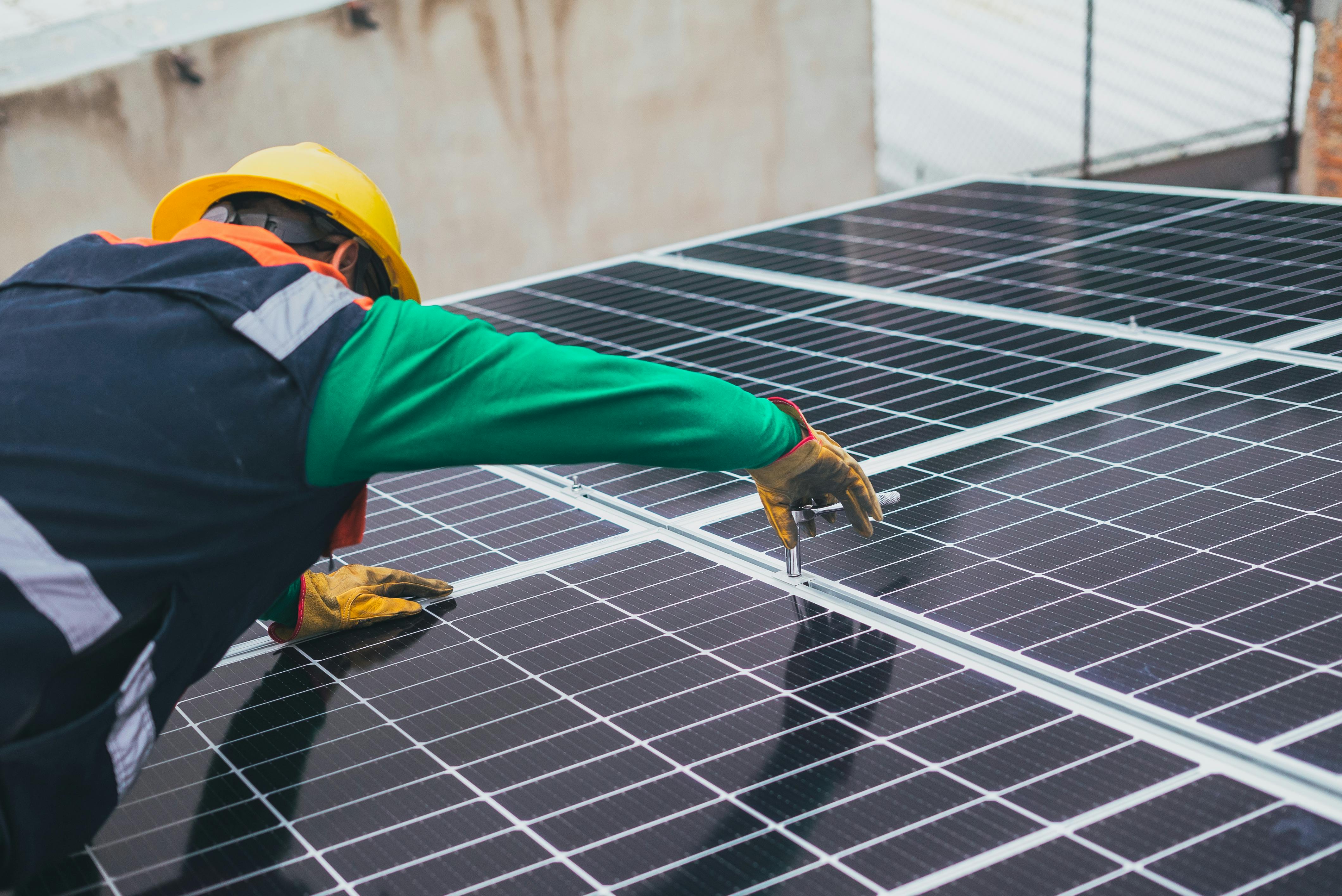 imagen Un operario coloca placas solares, una de las posibles medidas de descarbonización que pueden aplicarse. 