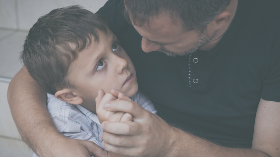 Niño que está siendo abrazado por un adulto