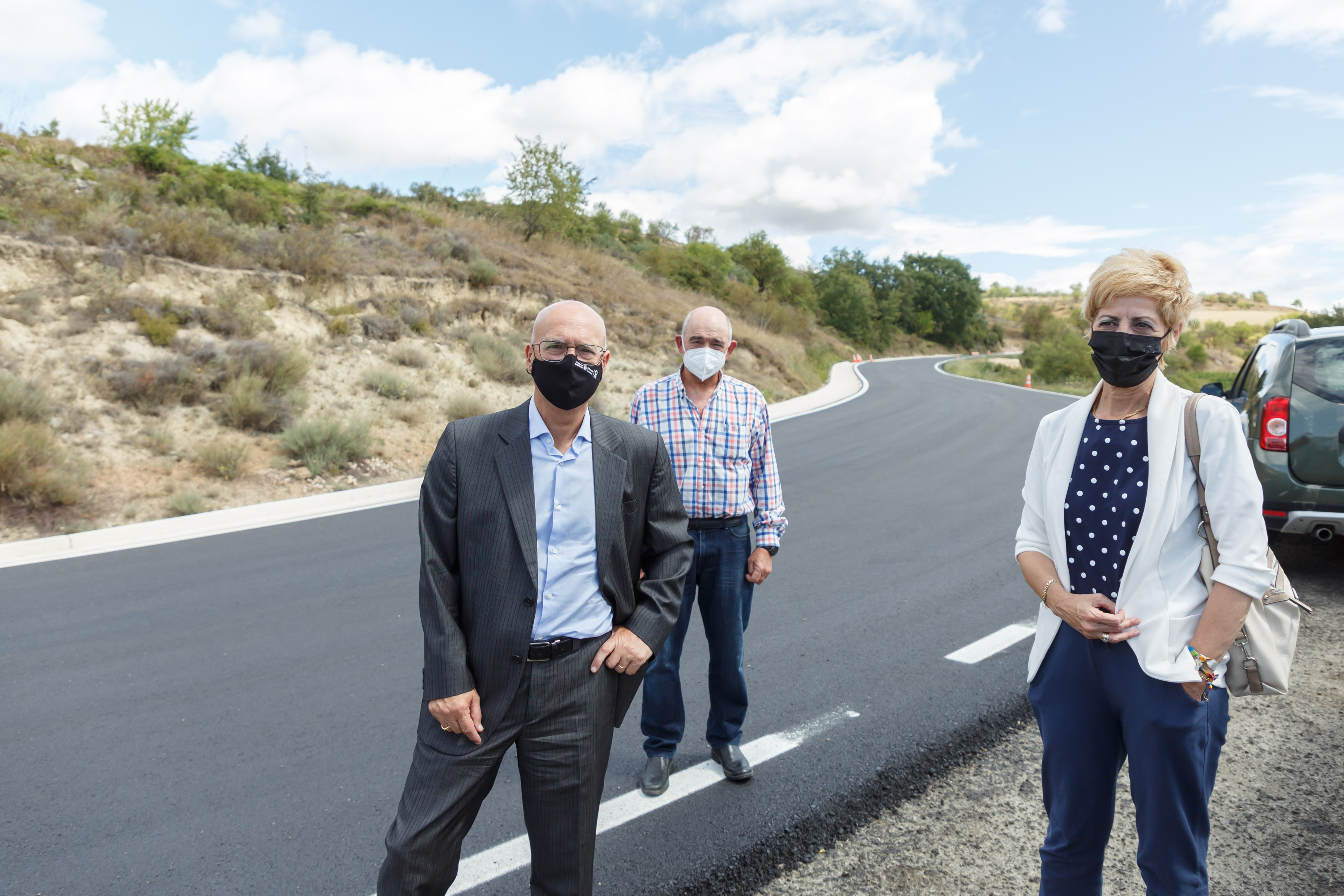 El consejero Ciriza, el alcalde de Aras, Jesús Carlos Fernández, y la alcaldesa de Viana, Yolanda González, en el tramo de carretera renovado entre ambas localidades.